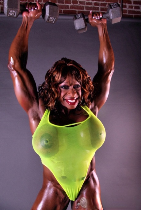Ebony bodybuilder Yvette Bova gets her huge fake tits out while working out