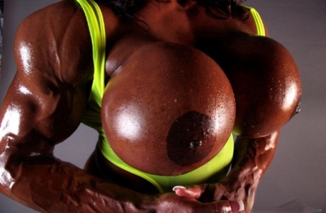 Ebony bodybuilder Yvette Bova gets her huge fake tits out while working out