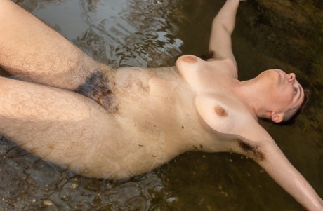 Brunette Harley Hex strips her swimsuit and washes her hairy body in the river