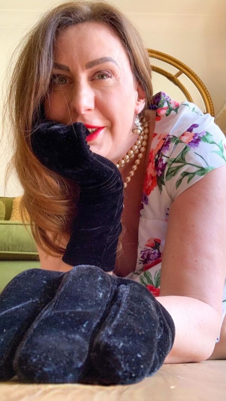 Saucy MILF Lara flashes her pussy while posing in her stockings, heels & dress