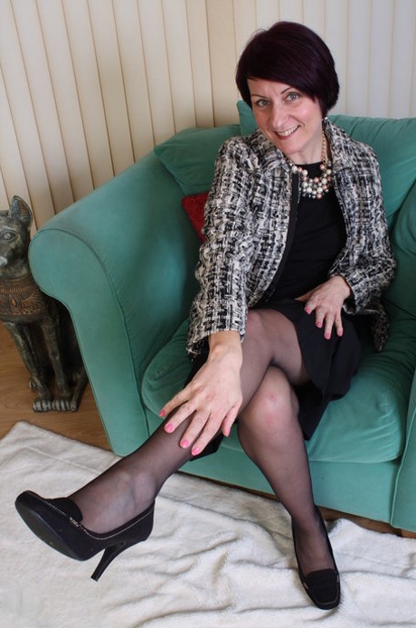 Mature with tiny tits Penny Brooks strips to lingerie and poses in a solo