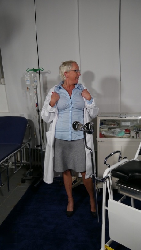 Short-haired doctor Anja stripping and masturbating at the office