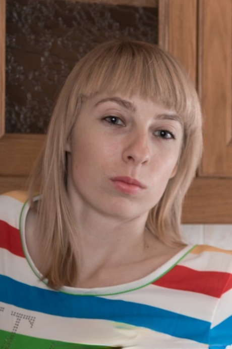 Blonde teen Natinella exposes her fine breasts and flaunts her bushy twat