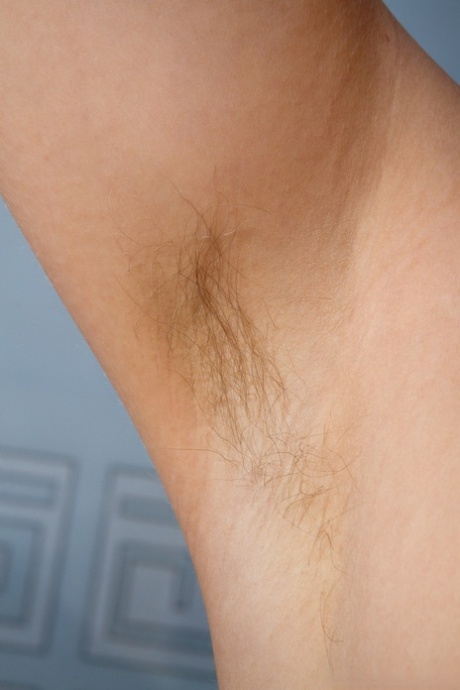 Lusty teen with hairy armpits Loredana exposes her bush and poses on a bed